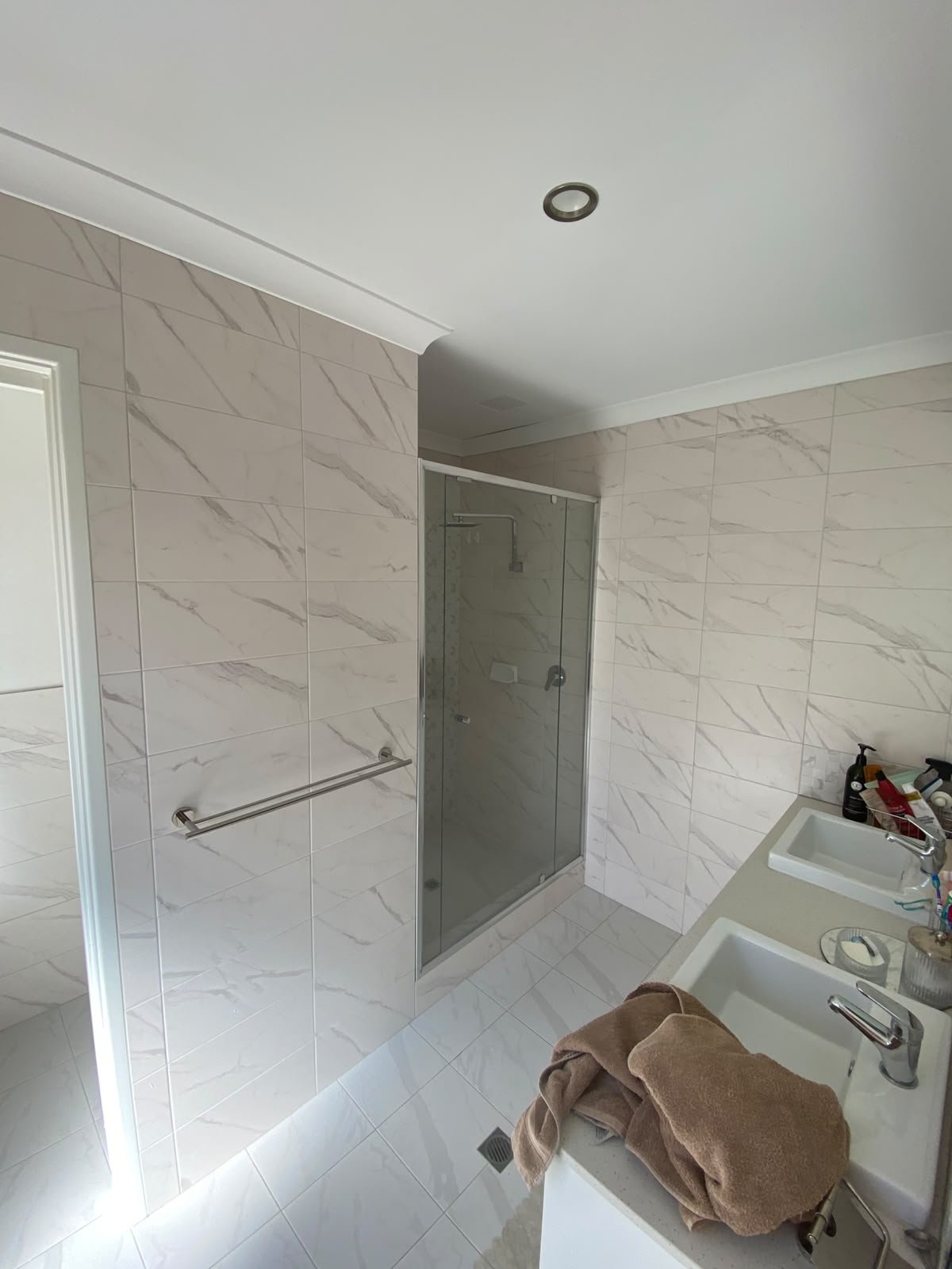 Luxury marble-look bathroom with frameless glass shower and double vanity by Rayan Tiling Services Perth