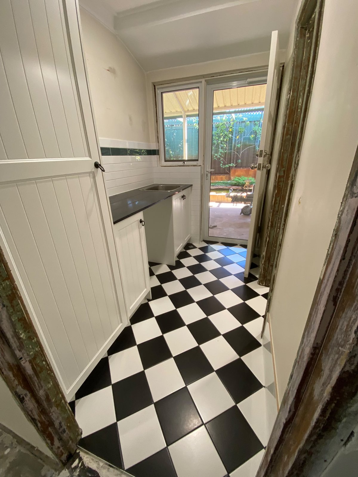 Black and white checkerboard floor tiling in a Perth laundry renovation