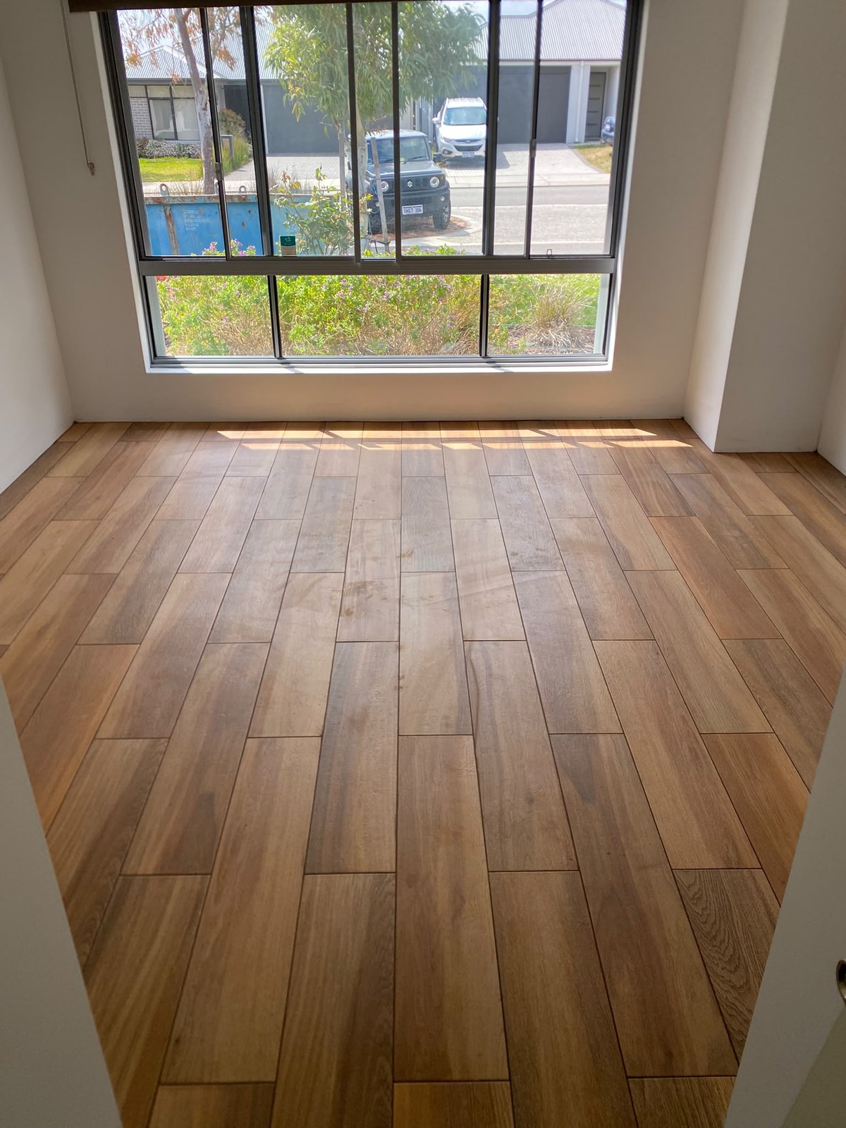 Timber-look porcelain plank floor tiling installed in a bright Perth room