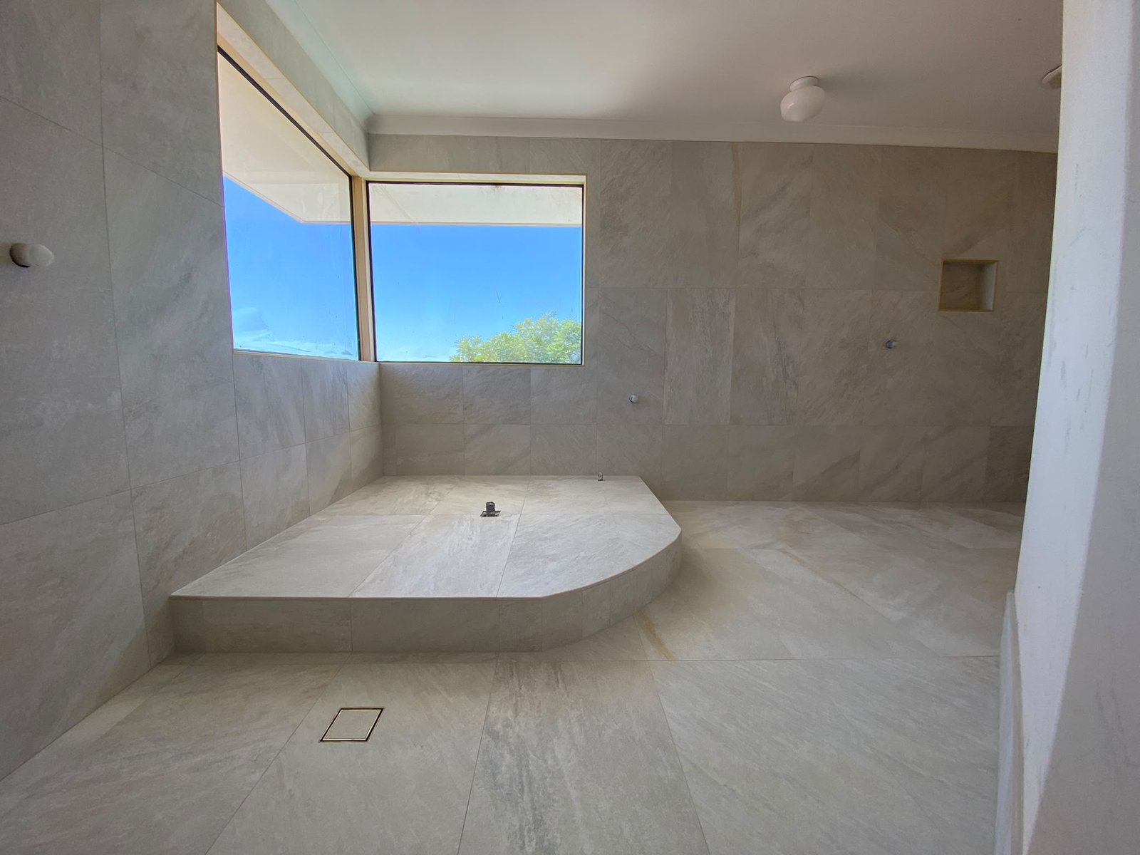 Luxury travertine-look bathroom with large-format wall and floor tiling in Perth