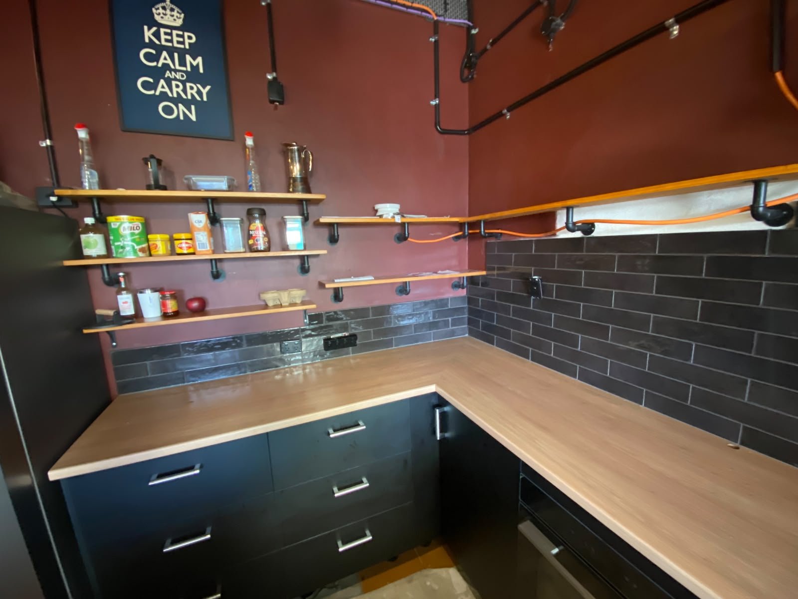 Dark gloss subway tile splashback with timber benchtop in a Perth scullery