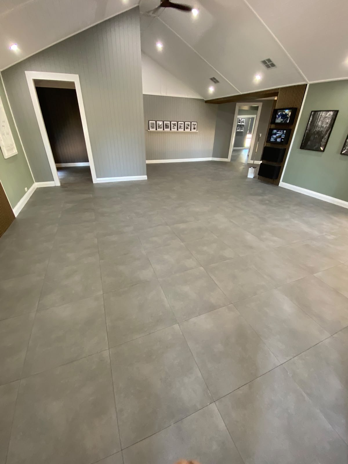 Large-format grey porcelain floor tiling in a vaulted open-plan Perth living room