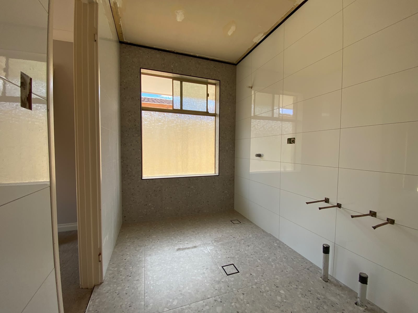 Terrazzo-look floor with white gloss wall tiling in a renovated Perth bathroom